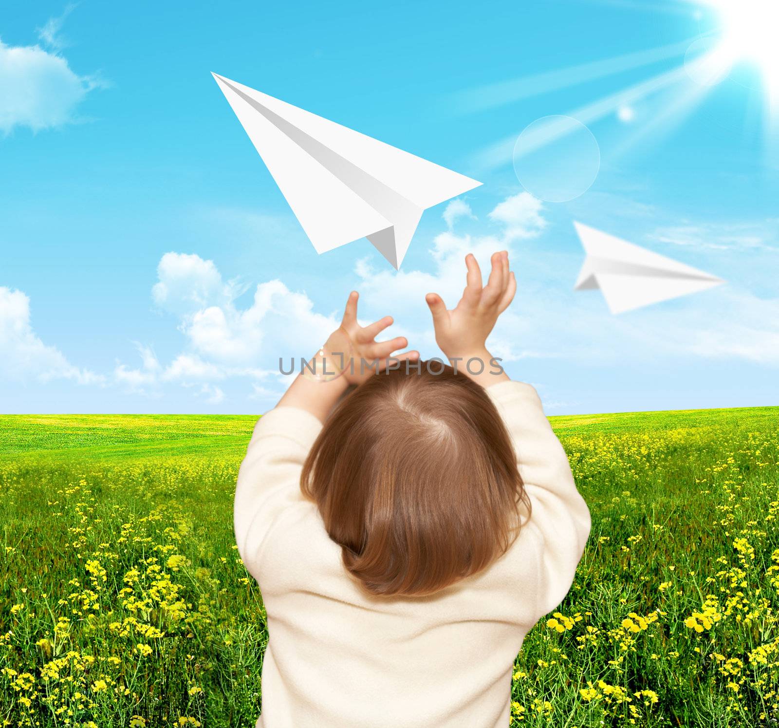 The small girl plays with the paper airplane by petrkurgan