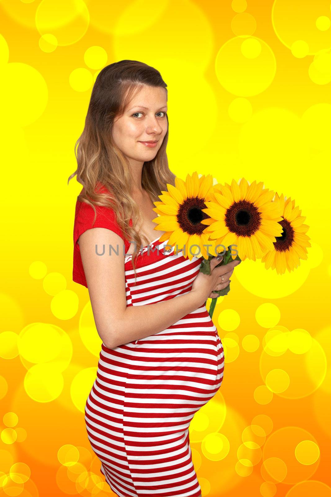 The pregnant woman holds in hands of sunflower
