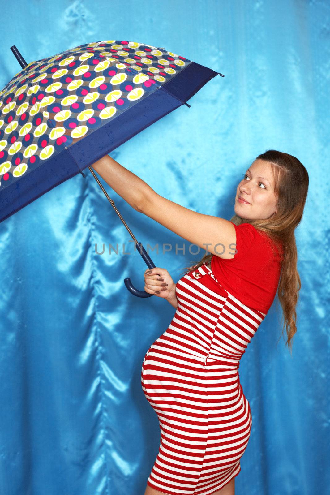A pregnant woman and umbrella on a blue background