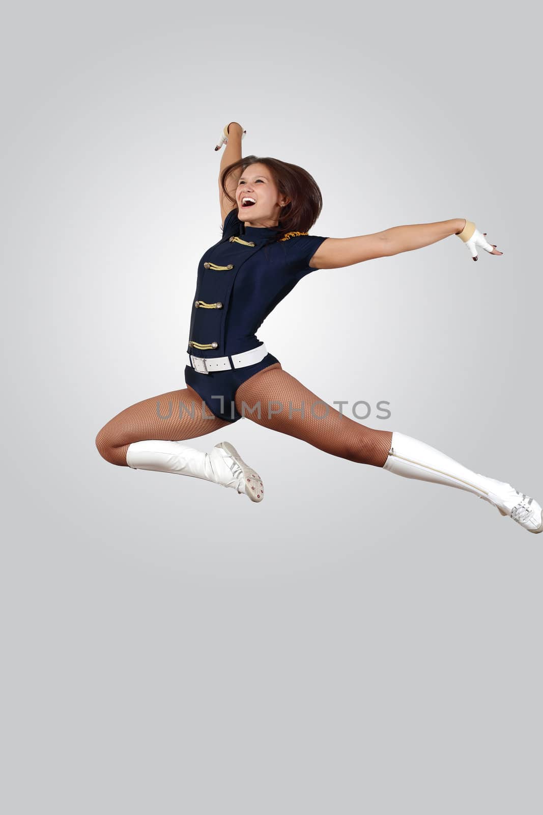 Young female dancer jumping against white background