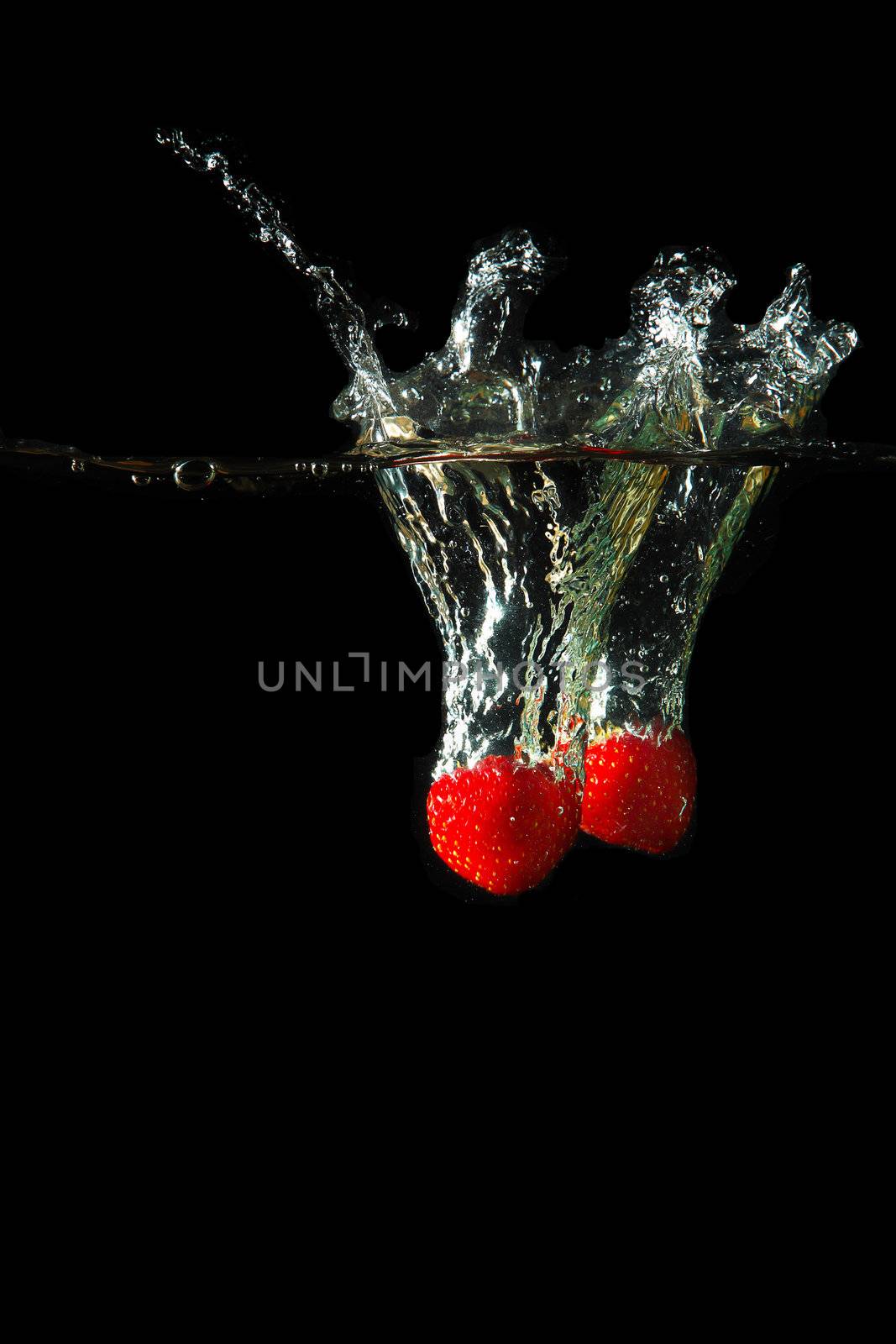 Colored red paprika in water splashes on black background