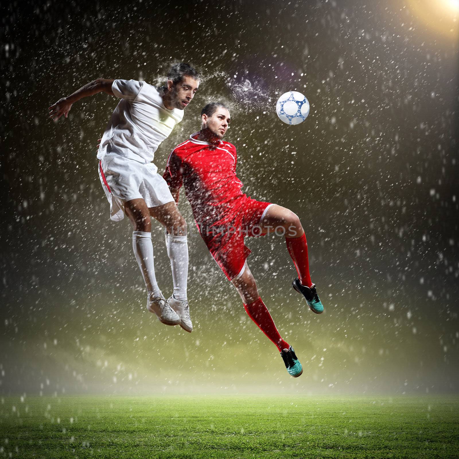 two football players striking the ball by sergey_nivens