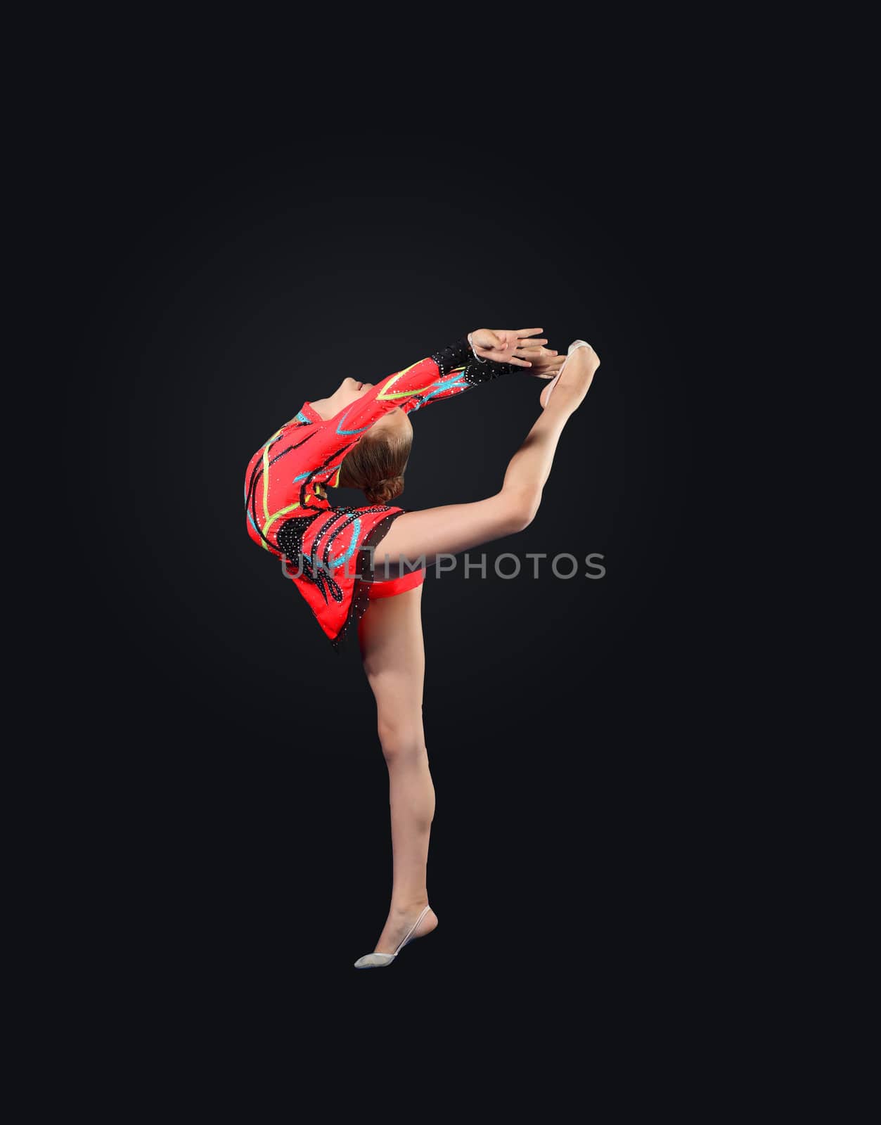 Young cute woman in gymnast suit show athletic skill on black background