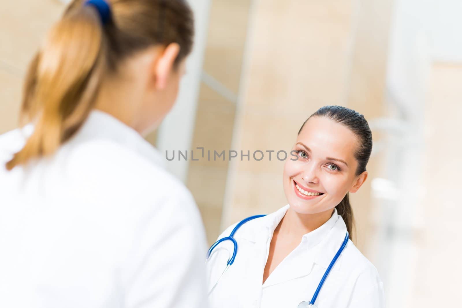 two doctors talking in the lobby of the hospital by adam121