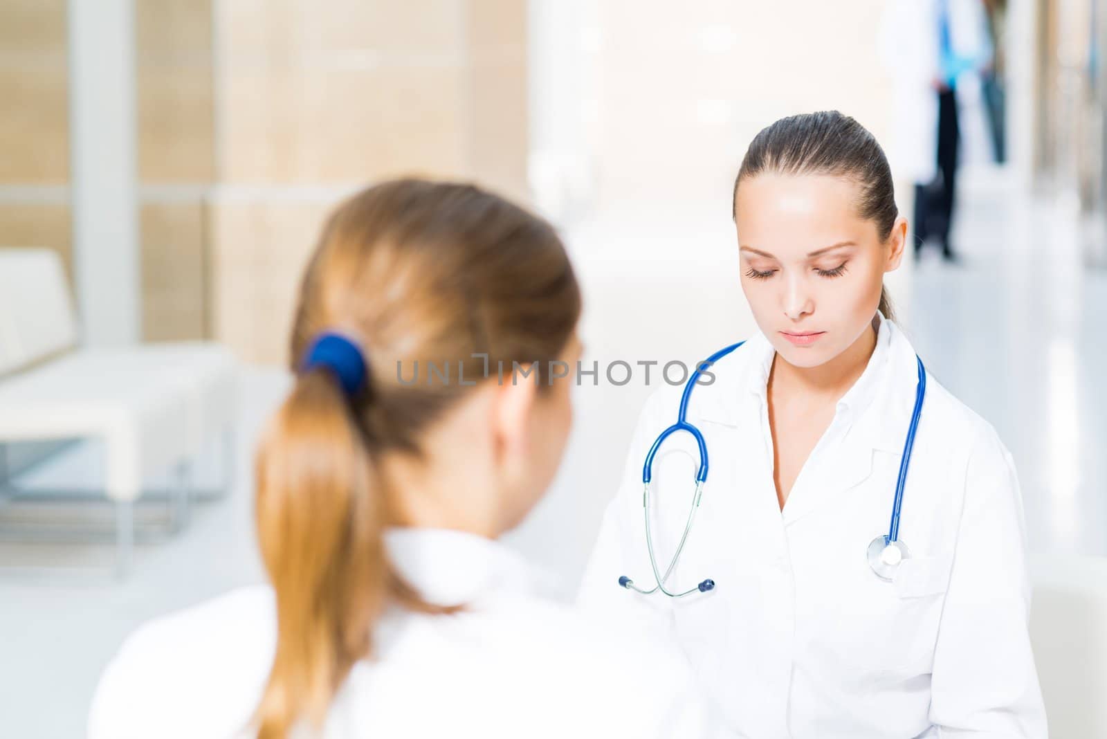 two doctors talking in the lobby of the hospital, sitting on the couch