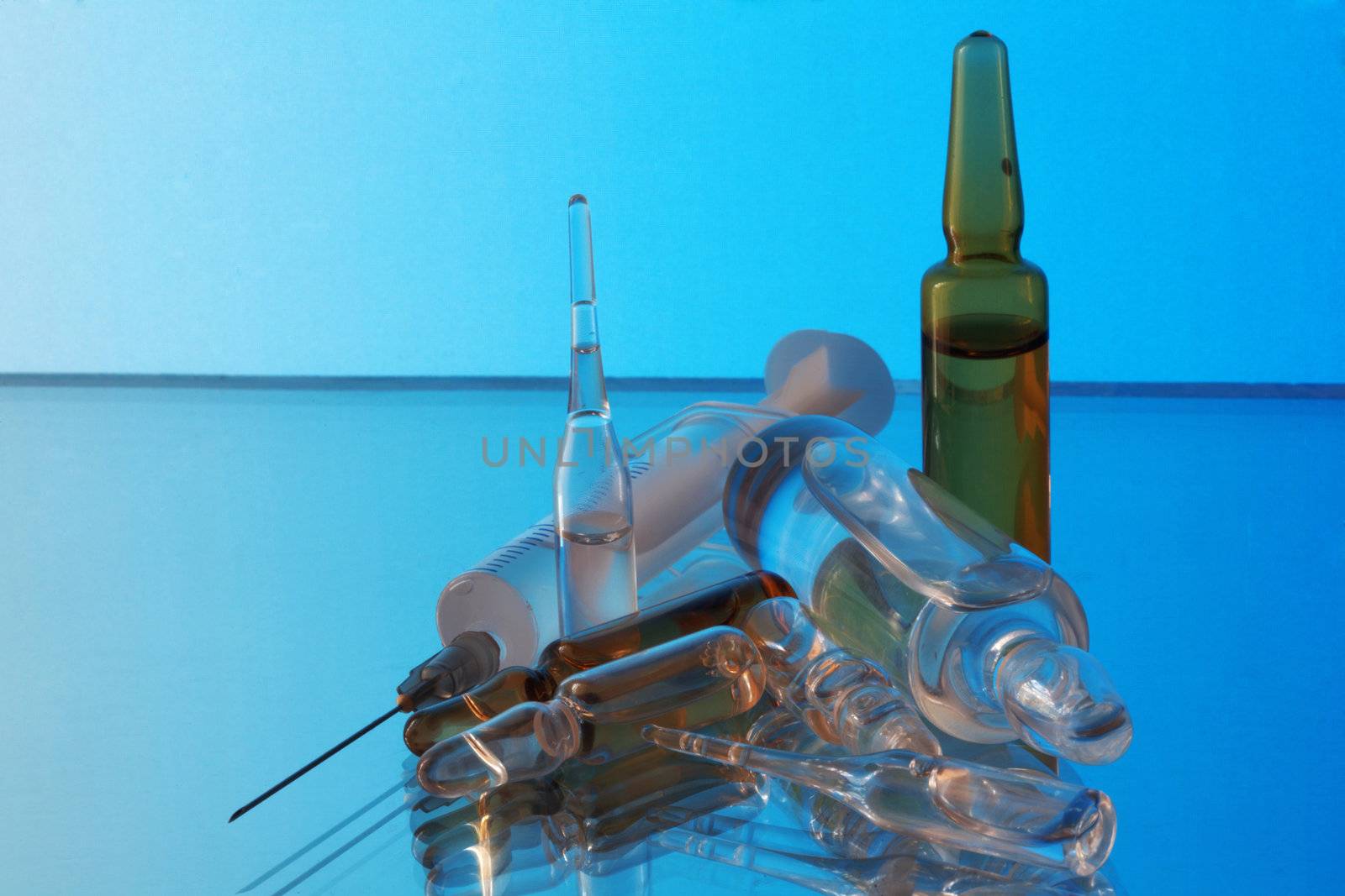 Medicine. Ampoules and syringe on a blue background