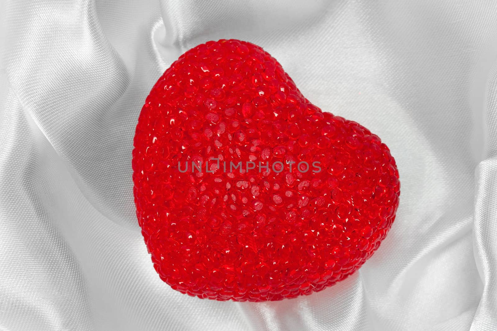 Red heart on white silk textured background
