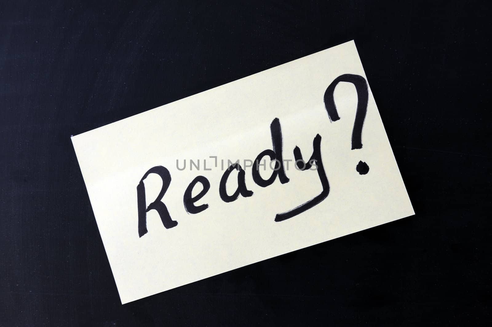 a notepaper which writes "Ready ?" on a chalkboard