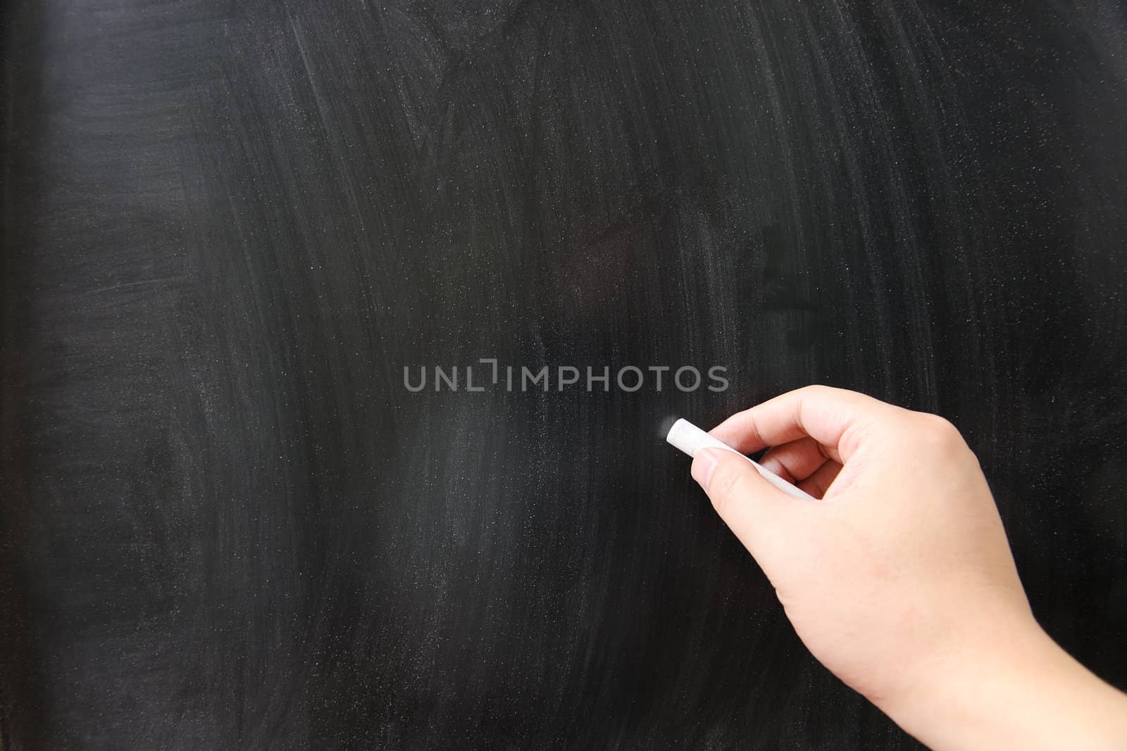 Hand writing on a blank chalkboard