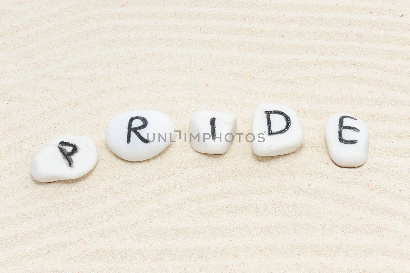 Pride word on group of stones with sand background