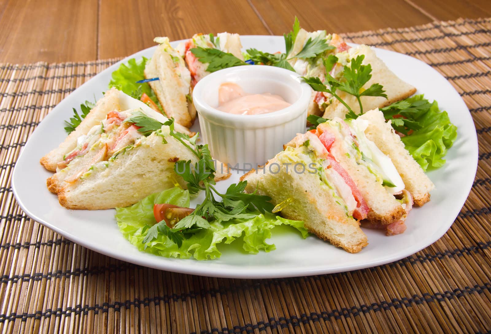 Canape with ham and egg and cup of sauce. closeup