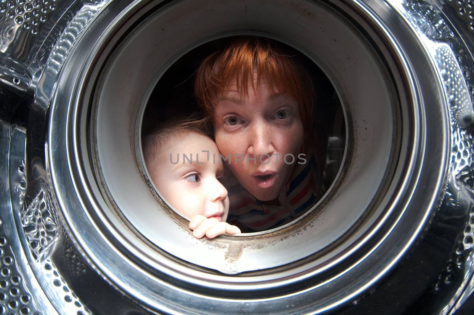 woman and boy peer into get old washer 