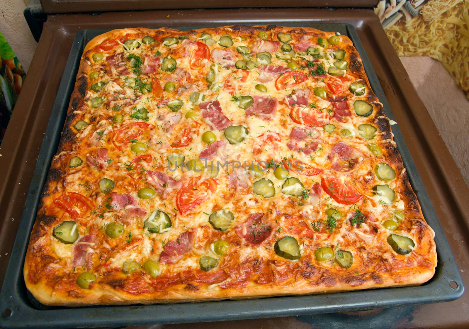 big pizza ham and vegetable on baking sheet 

