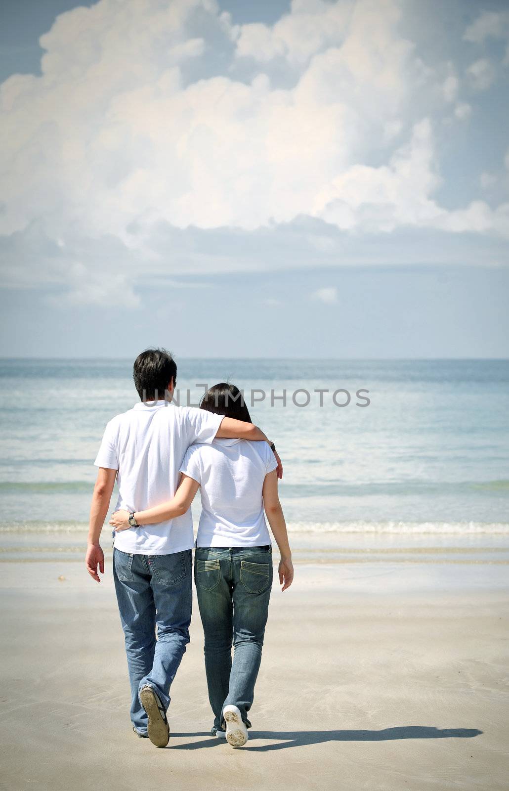 romantic couples walking together on the beach