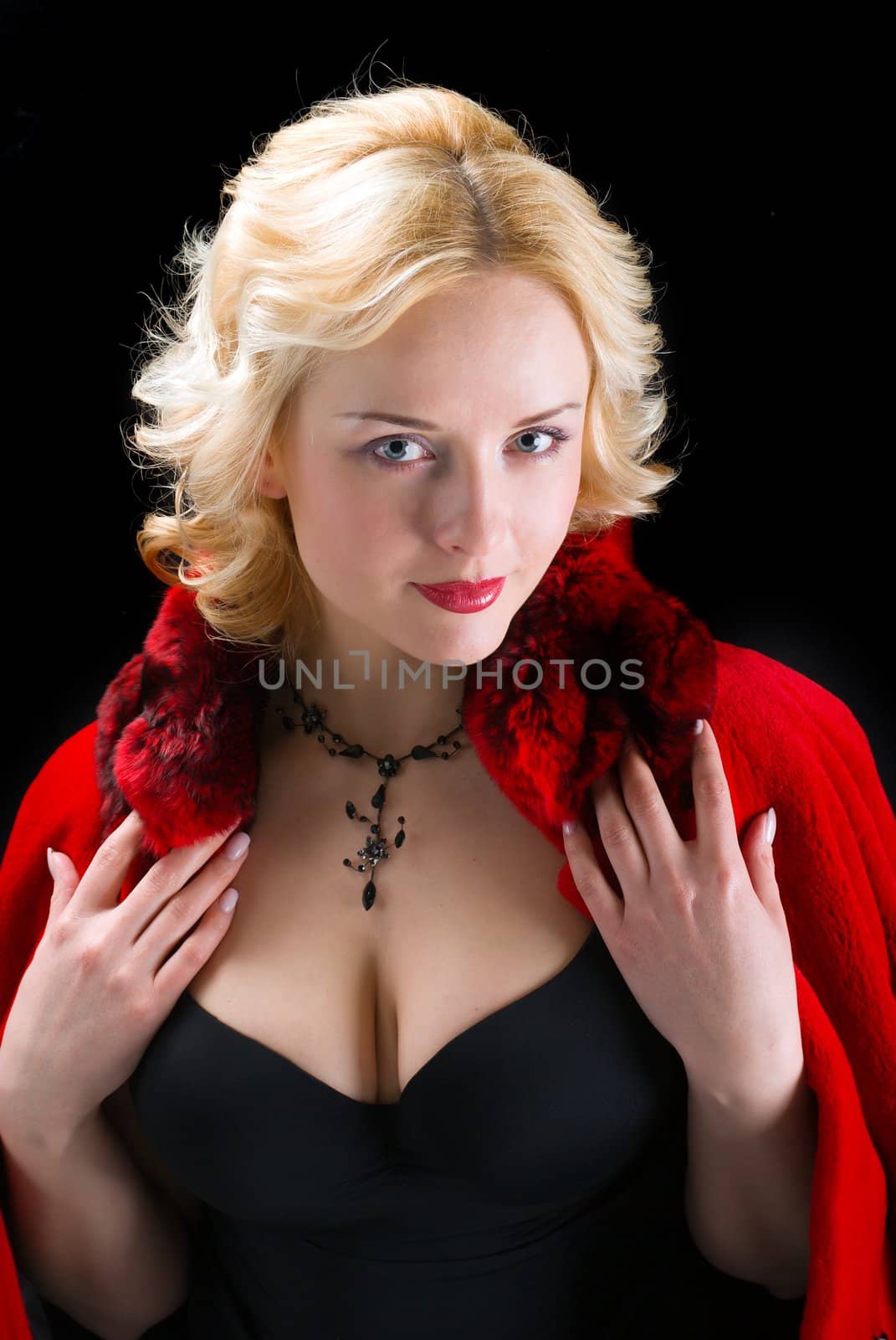 Sexy model wearing winter fur red  coat on  black  background 