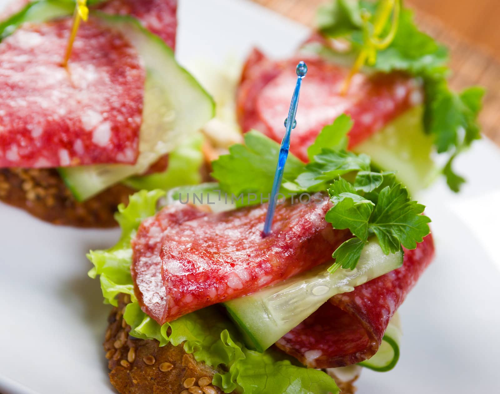 Canape with salami and cucumber. Shallow depth-of-field. 