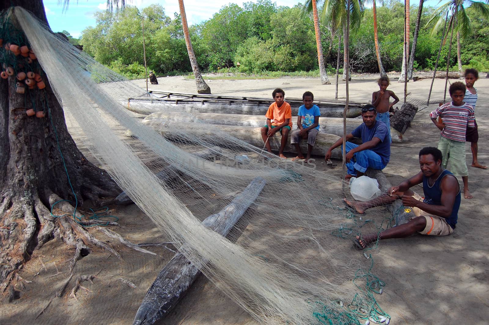 Fishermen cleaning net in Papua New Guinea village by danemo