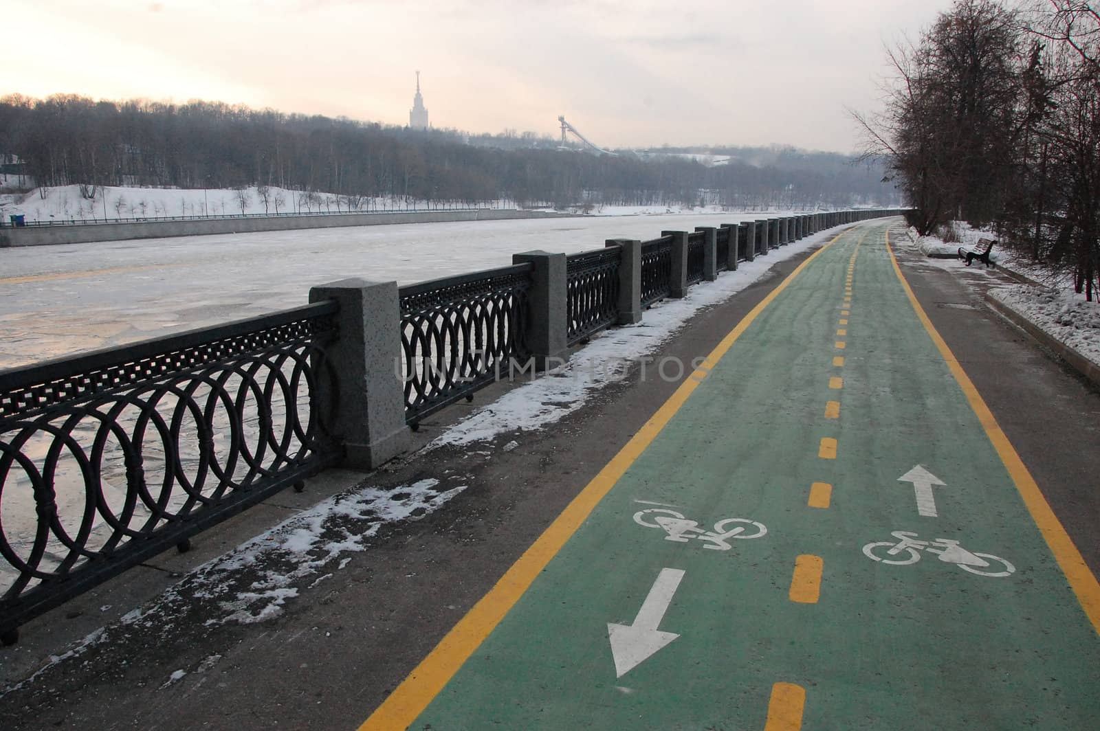 Green bicycle path at winter riverside by danemo