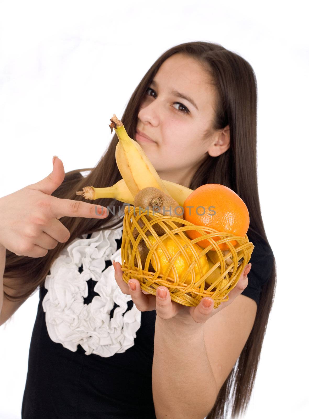 Beautiful girl holds out a basket of citrus fruit
