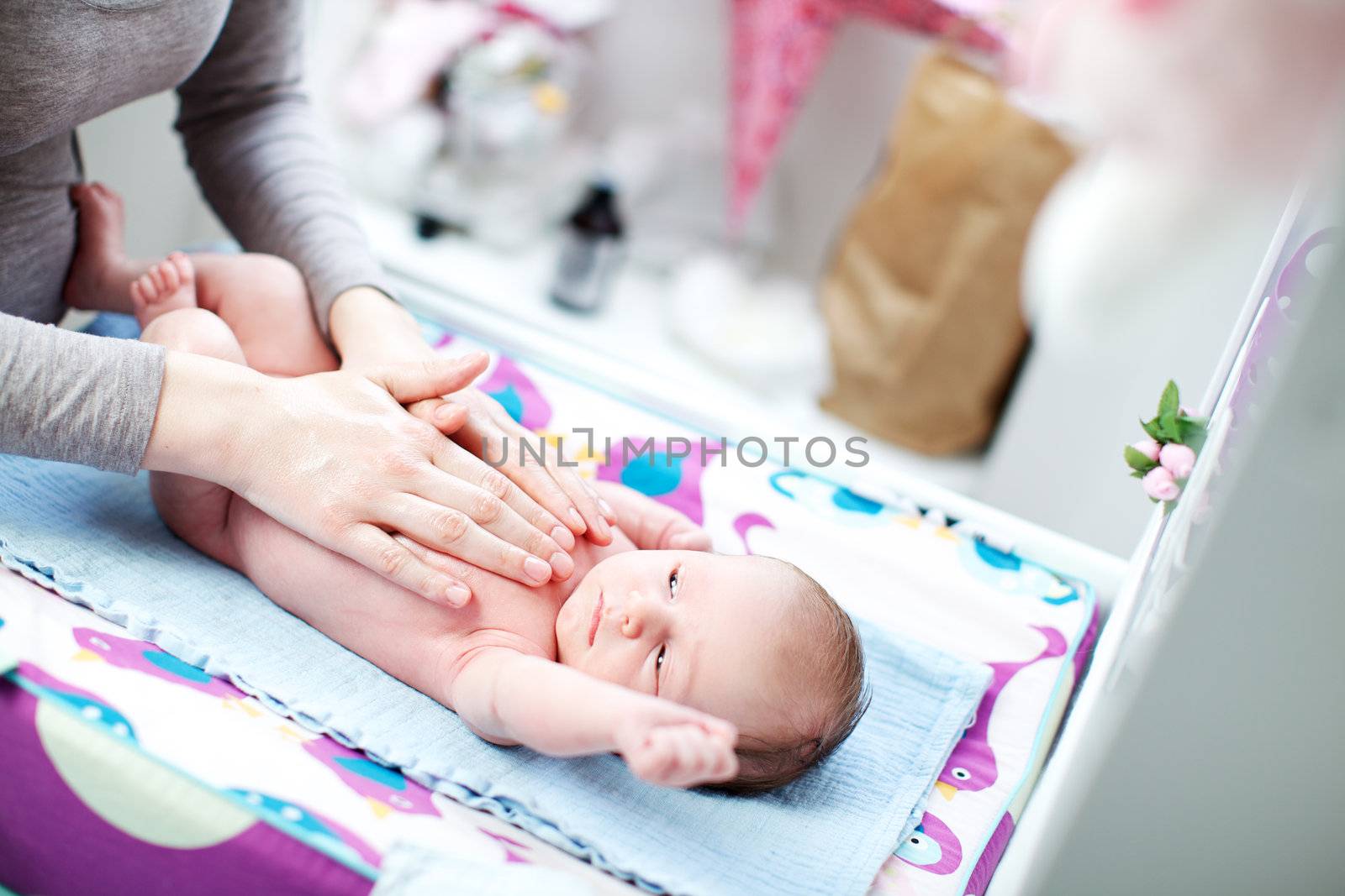 New born baby lying in bed caressed by mother by langstrup