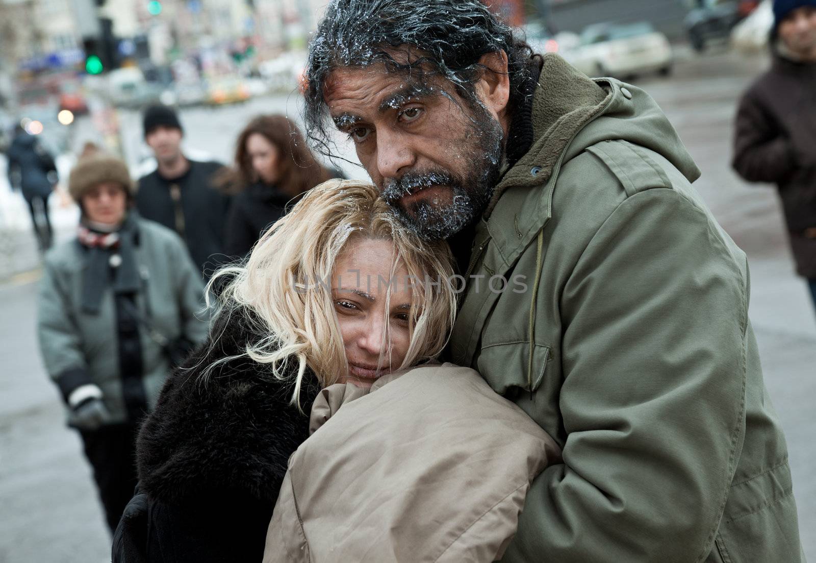 Homeless frozen couple embracing by vilevi