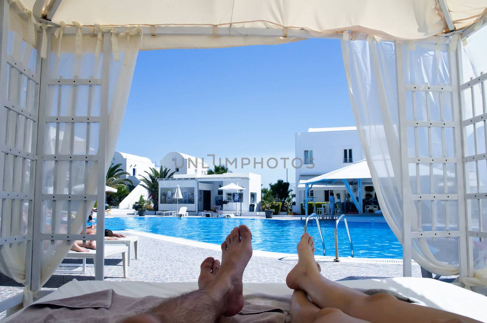 Feets on a Canopy Bed with view to the Pool