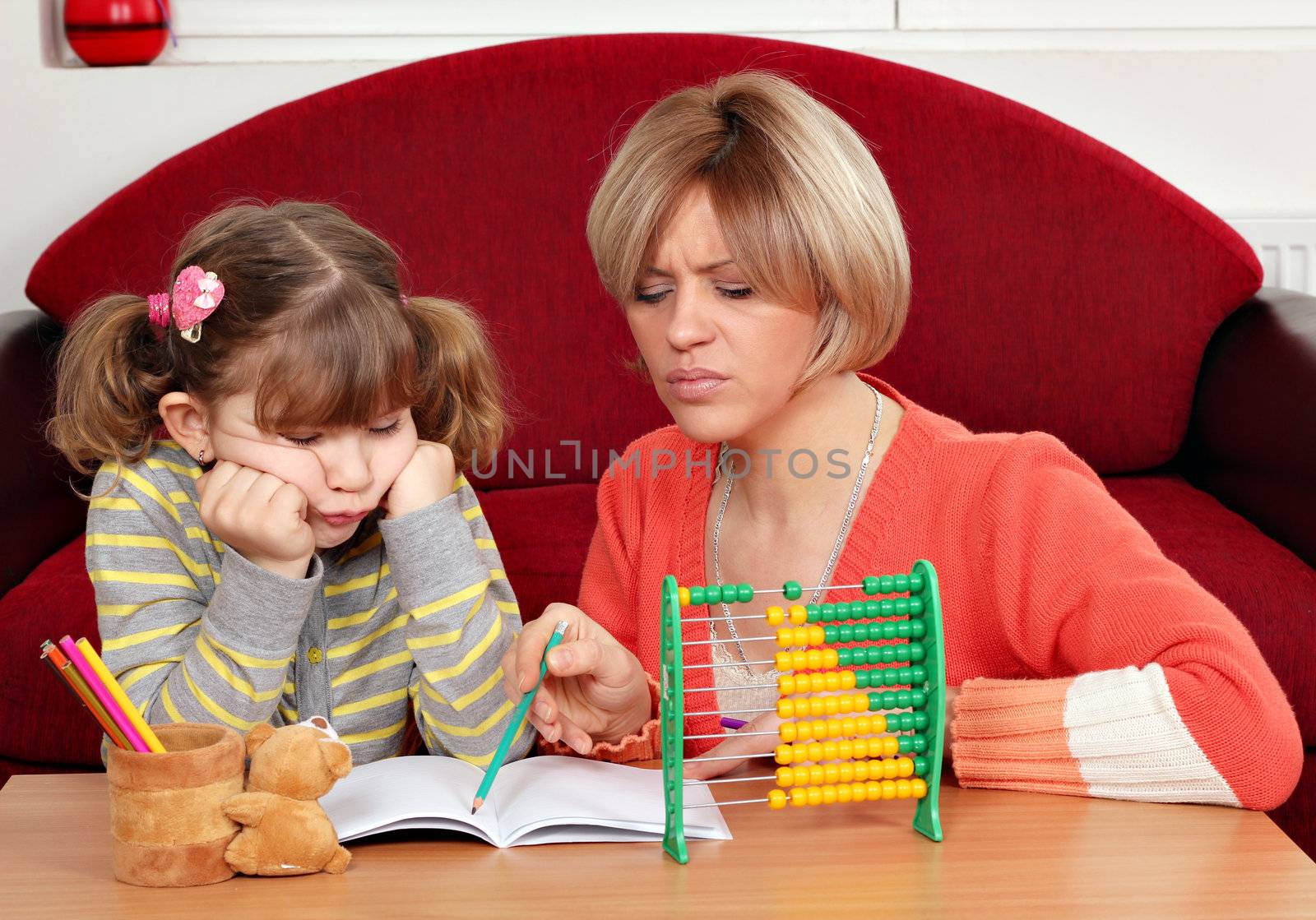 unhappy daughter and mother doing homework