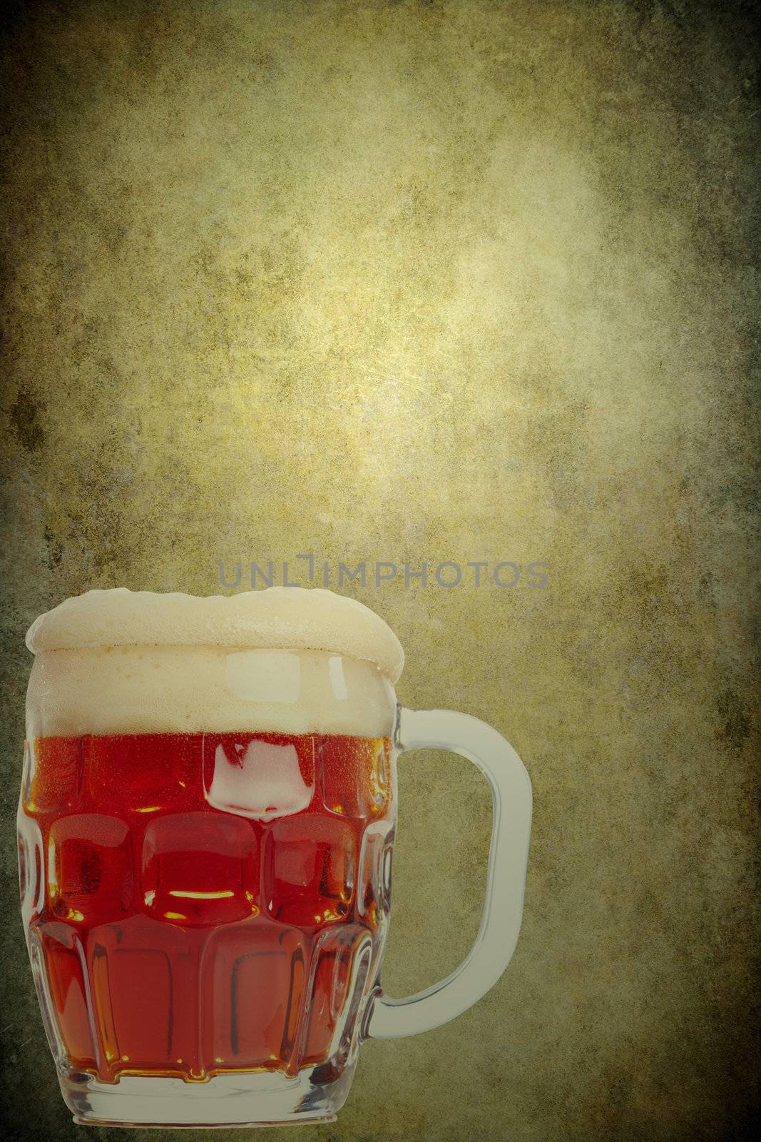 Glass with beer on the old brown paper