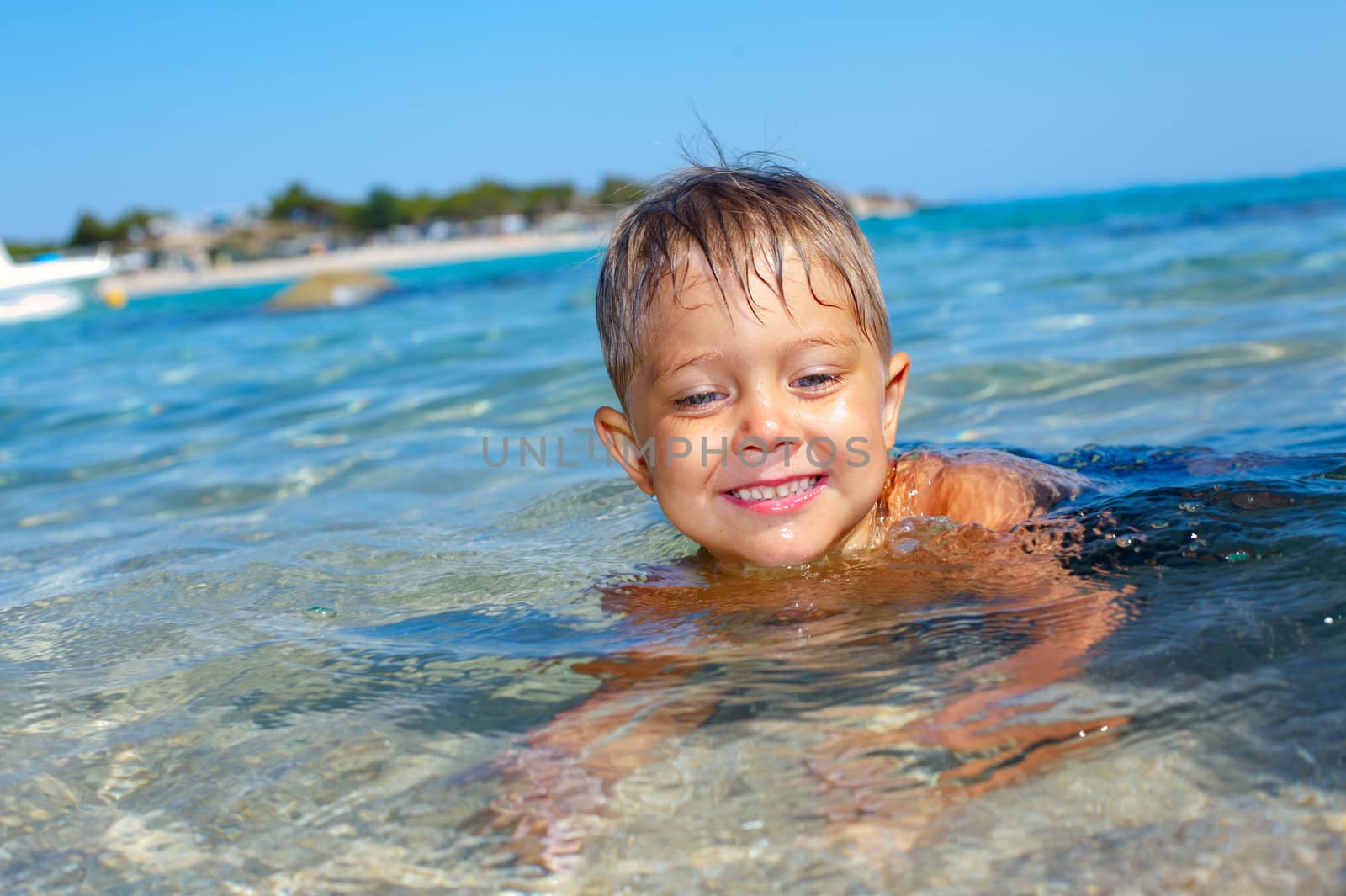 Young boy in the sea by maxoliki