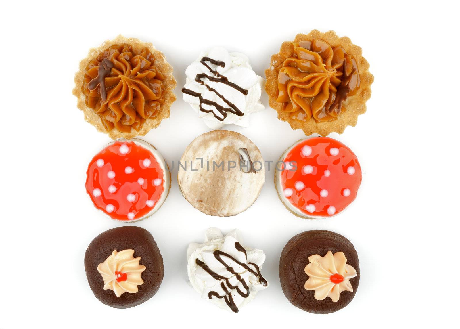 Arrangement of Chocolate Cupcakes,  Tartlet, Strawberry Jelly Cheesecake Polka Dot and Dark Chocolate Glazed Meringue isolated  on white background. Top View