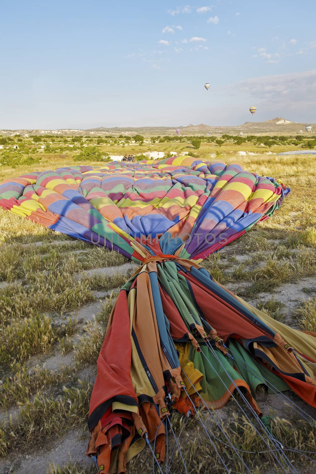 vertical landscape of a group of roadies packing away a hot air balloon after a passenger flight. Generic shot location Cappadocia Turkey