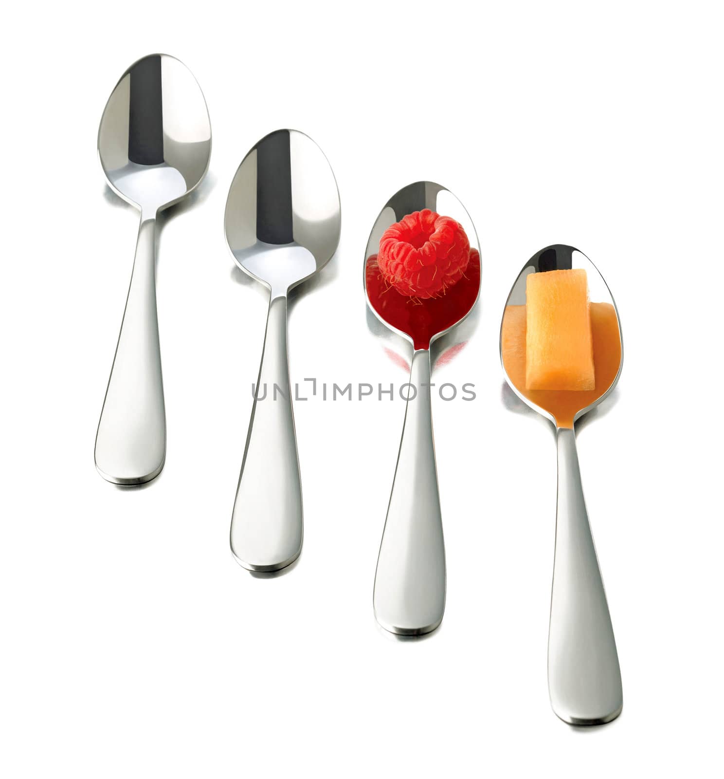 four spoons on white background. raspberry on spoon