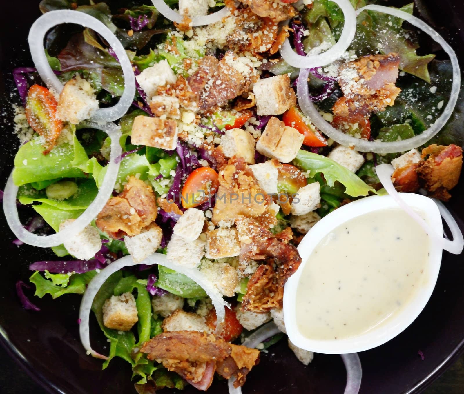 Salad with cream sauce in black dish