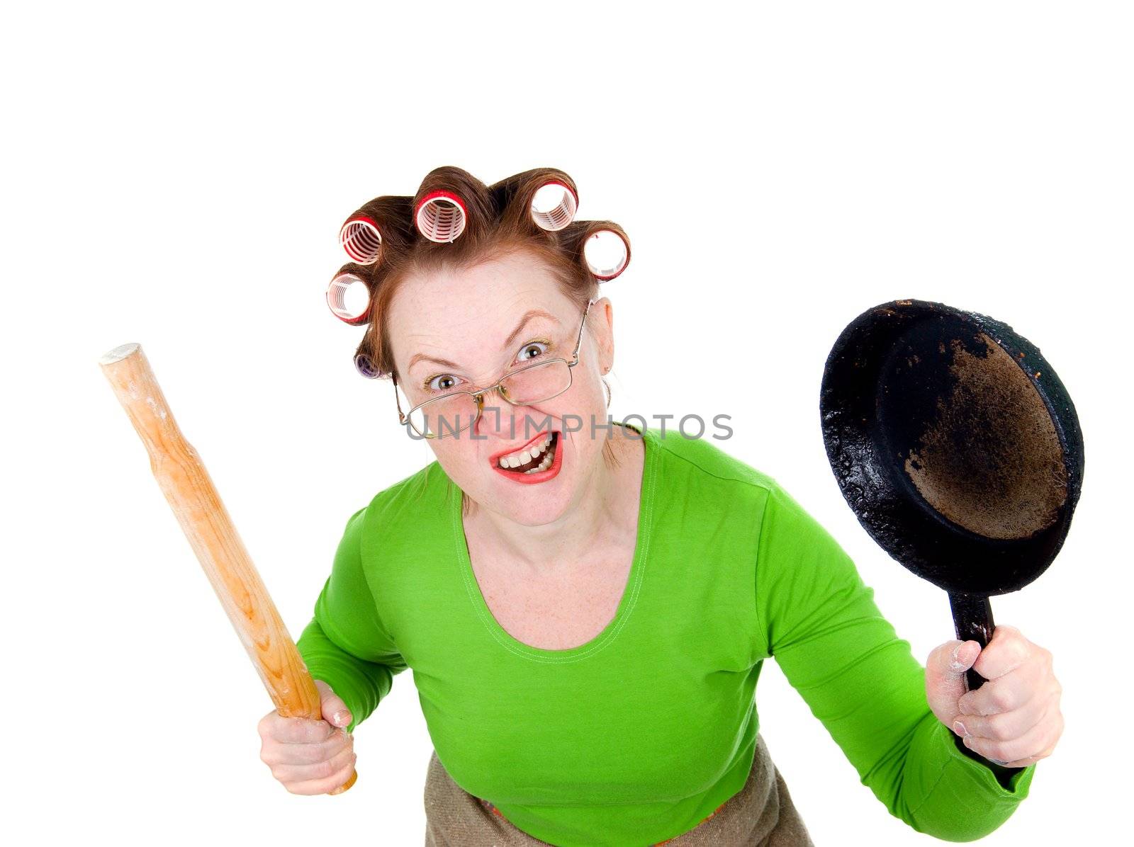 Angry crazy  housewife in hair rollers is holding.Angry look on face. Studio, white background. 