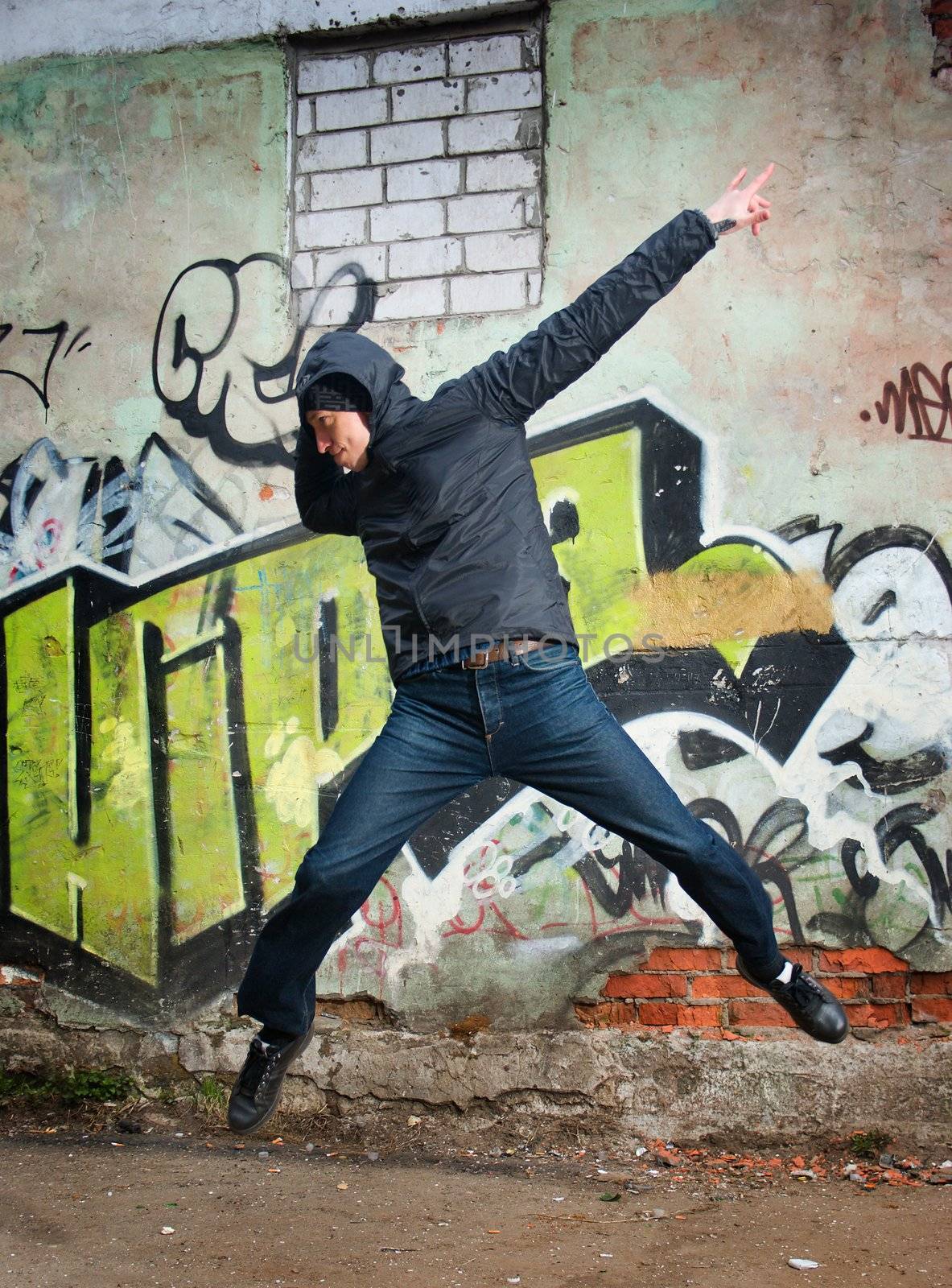 cool looking dancer posing on a grunge background with graffiti 