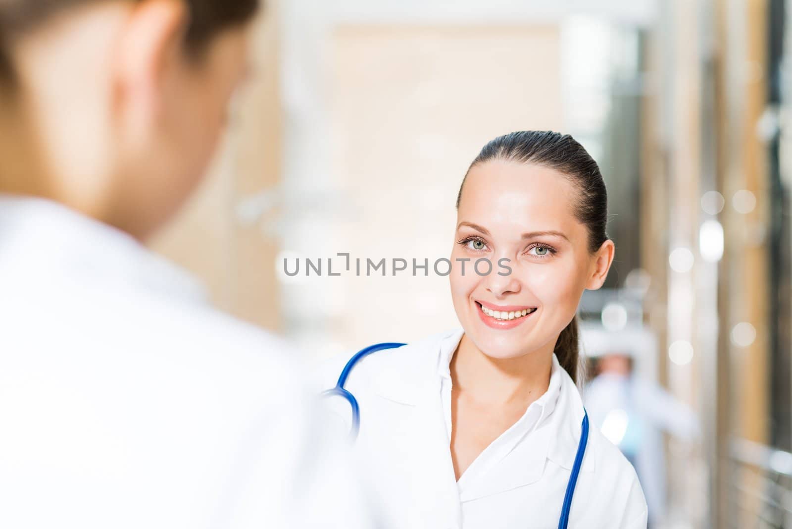 two doctors talking in the lobby of the hospital, sitting on the couch