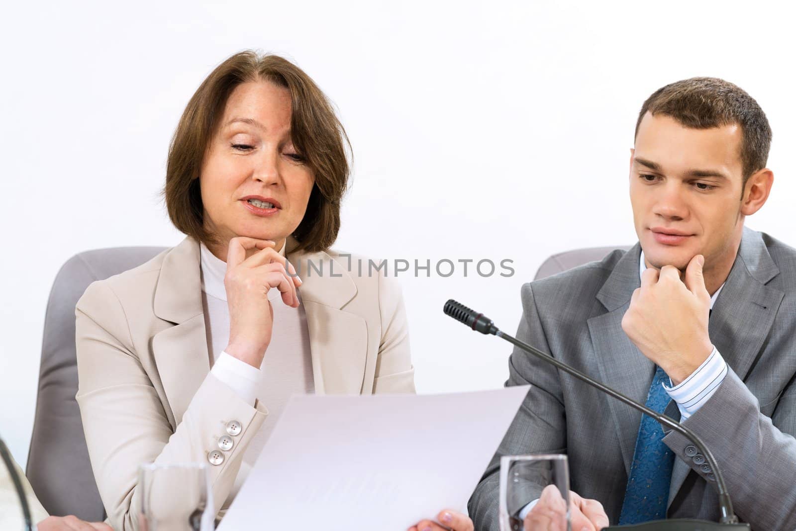 Senior business woman working with documents at the conference, on the table microphone stand