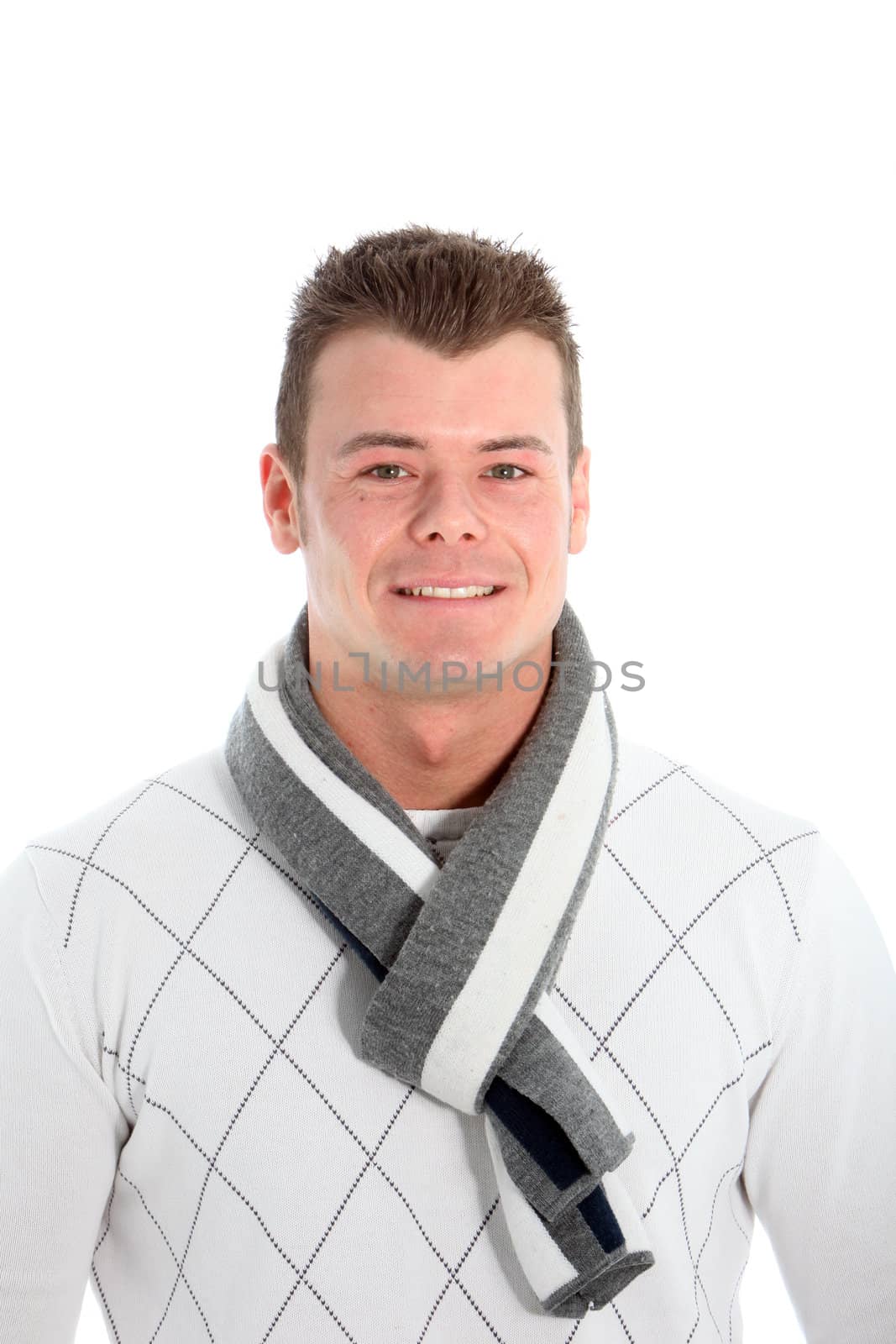 Handsome young man with a friendly smile standing in a stylish winter scarf isolated on white