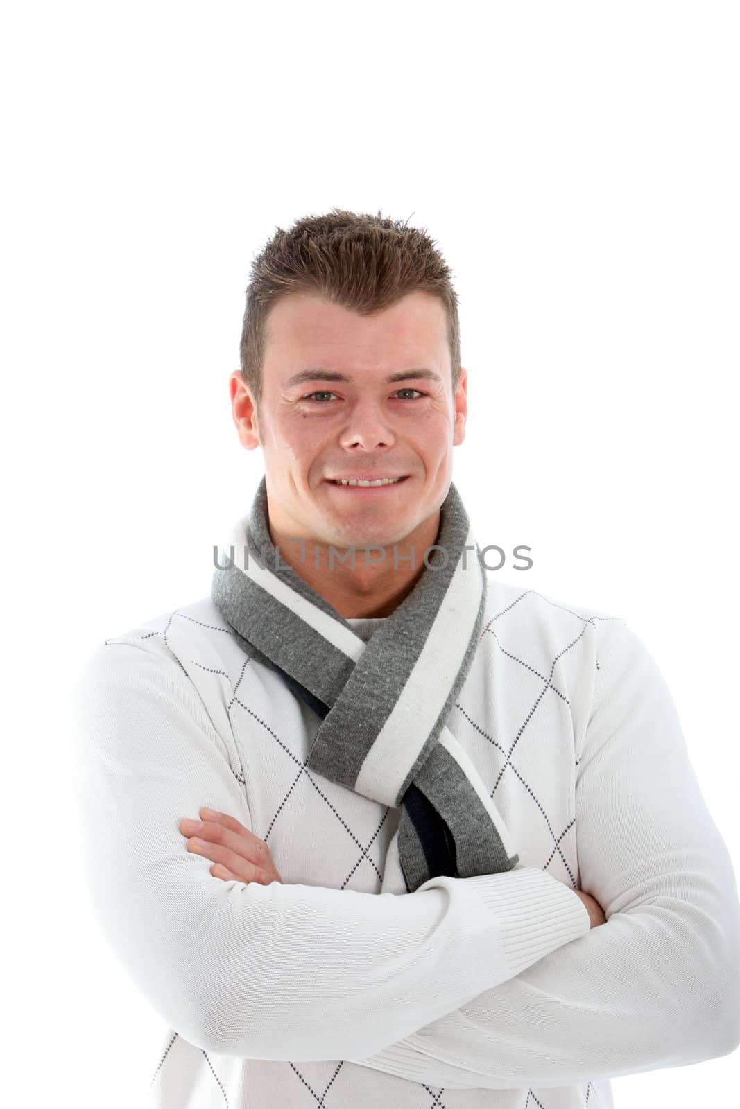 Smiling confident good-looking young man in a scarf standing with his arms folded across his chest isolated on white