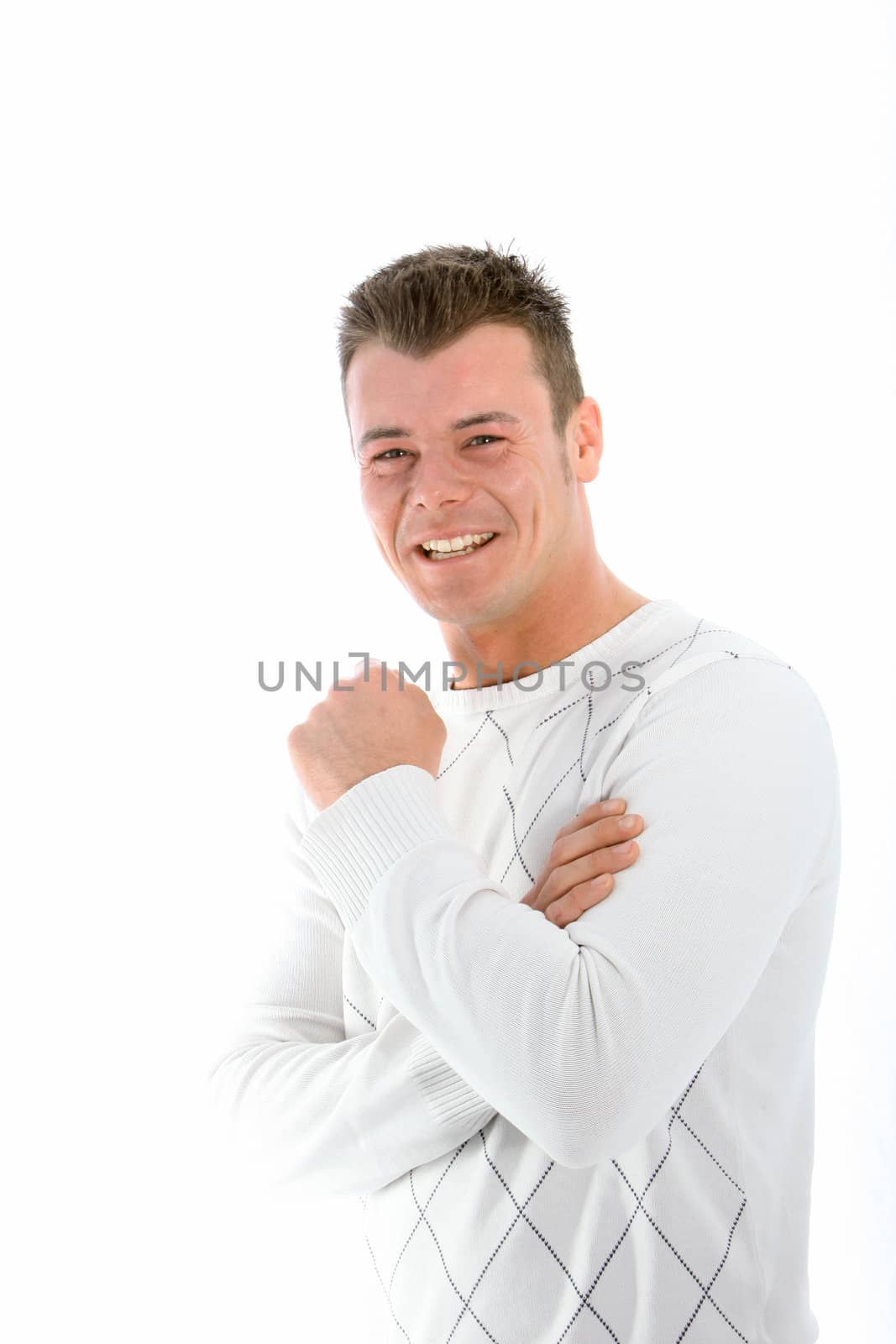 Laughing handsome young man in a winter top standing with his arms folded looking at the camera isolated on white