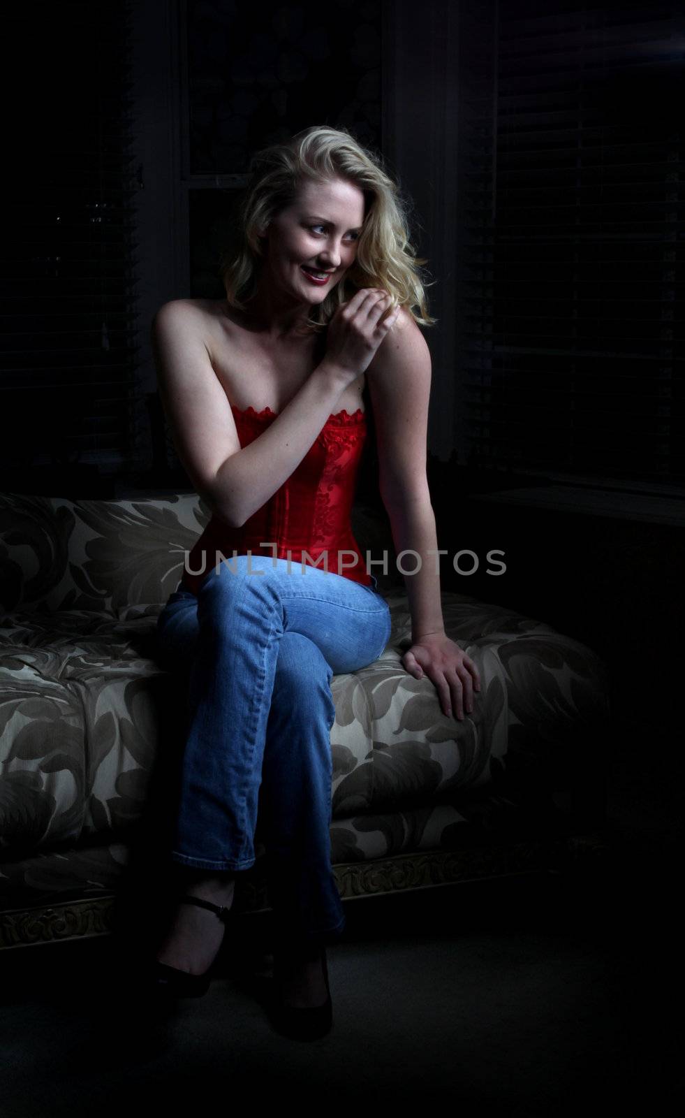 Sexy blond woman sitting in the dark.