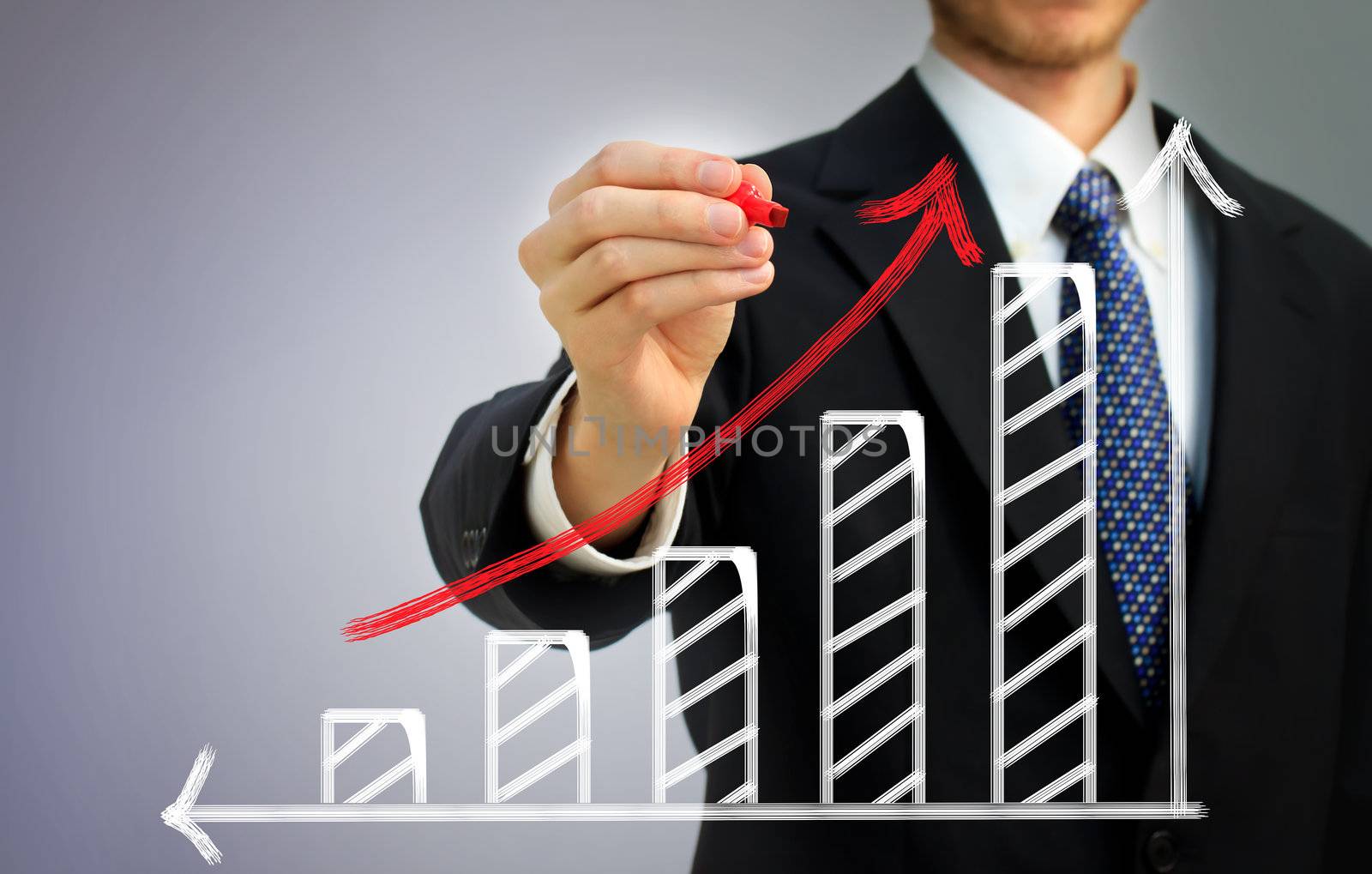 Businessman drawing a rising arrow over a bar graph