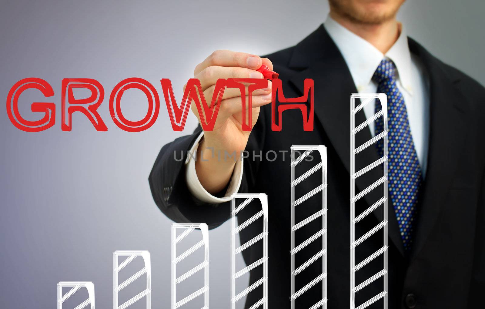 Businessman writing growth over a rising bar graph