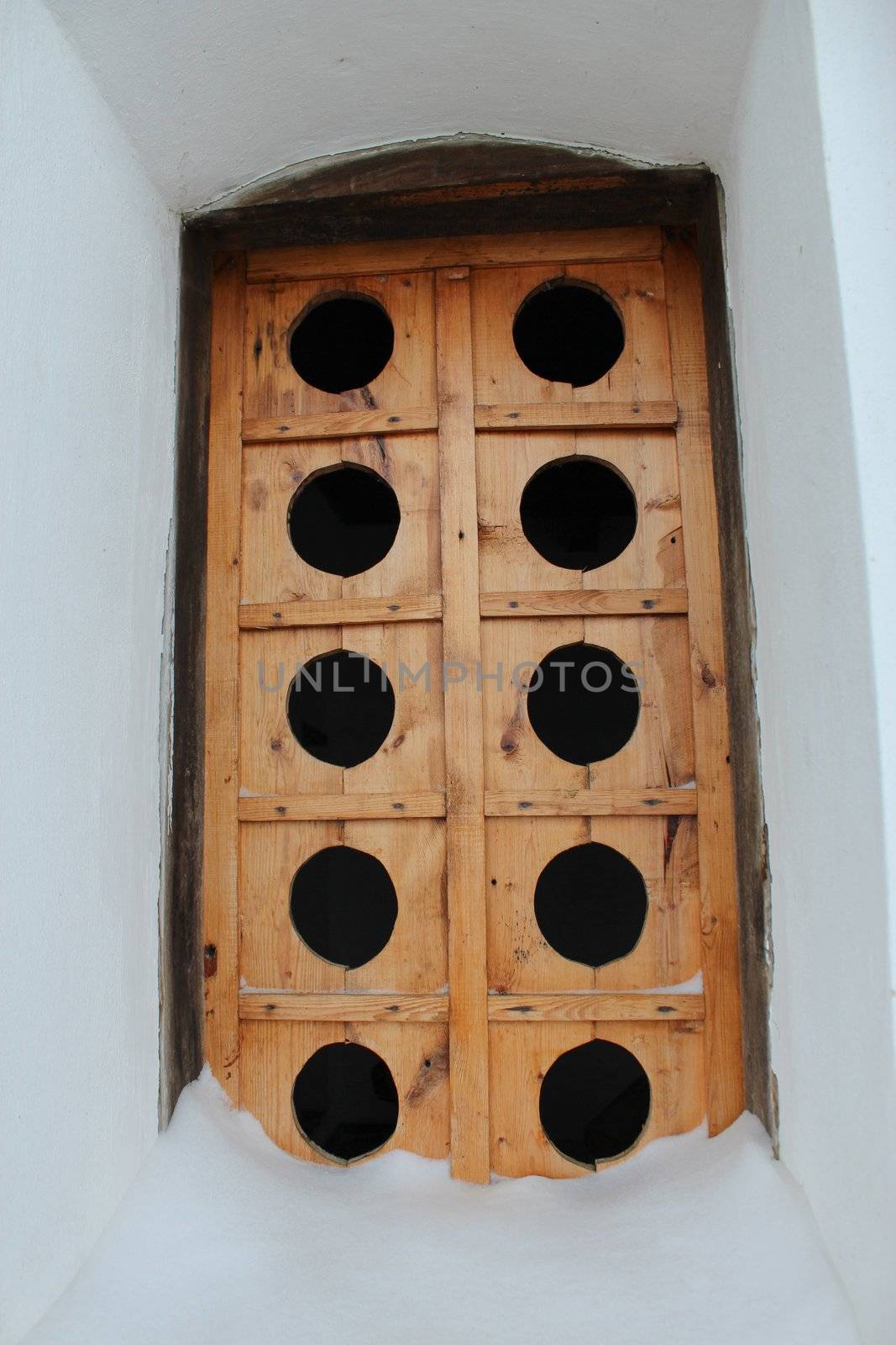 Ancient wooden window with a unusual pattern in a wall