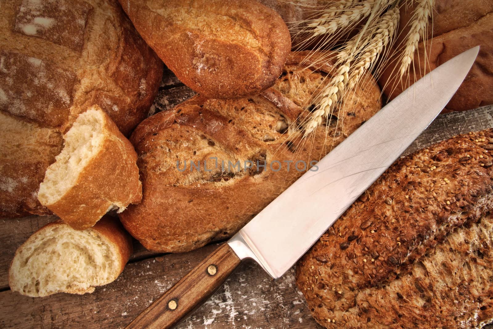 A selection of bread loaves with knife by Sandralise