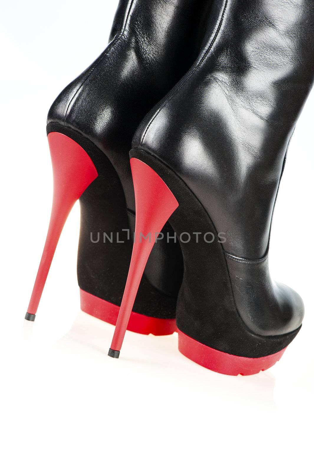 Close-up shot of a pair of fetish boots, high heels with platform, black and red color. 