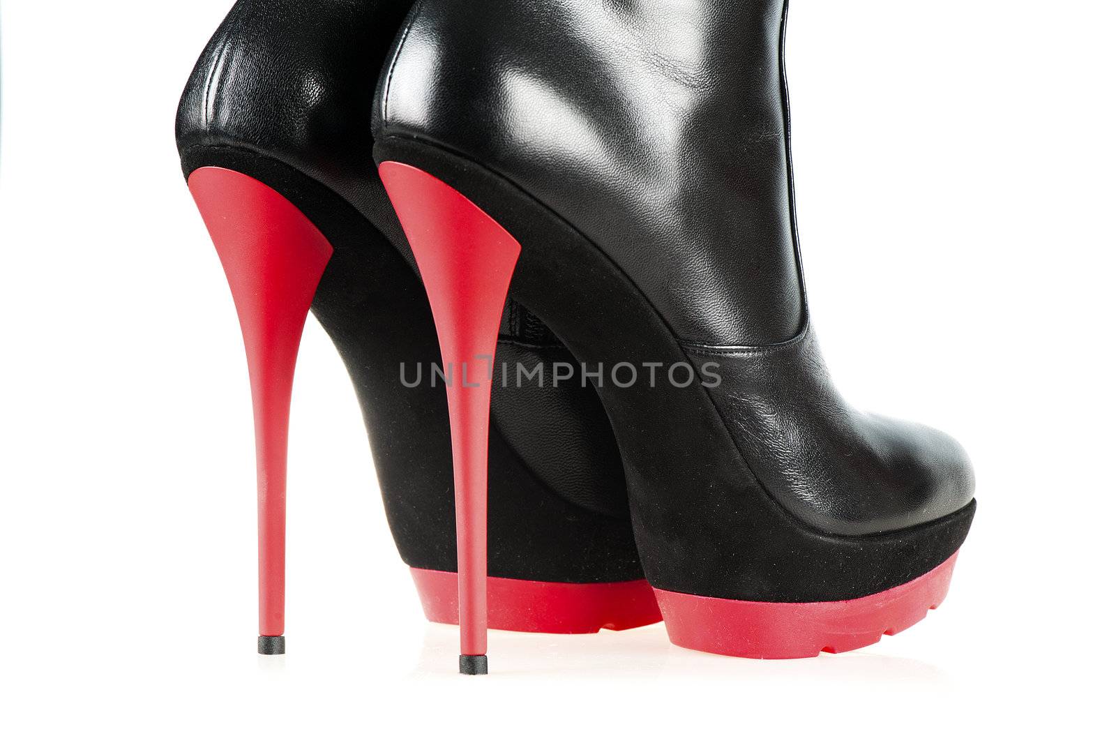 Close-up shot of a pair of fetish boots, high heels with platform, black and red color.