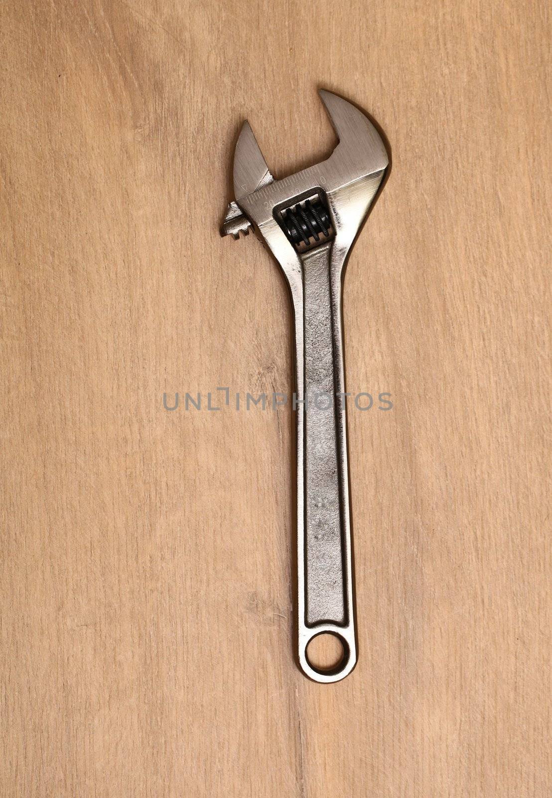 Metal spanner isolated on a wooden table