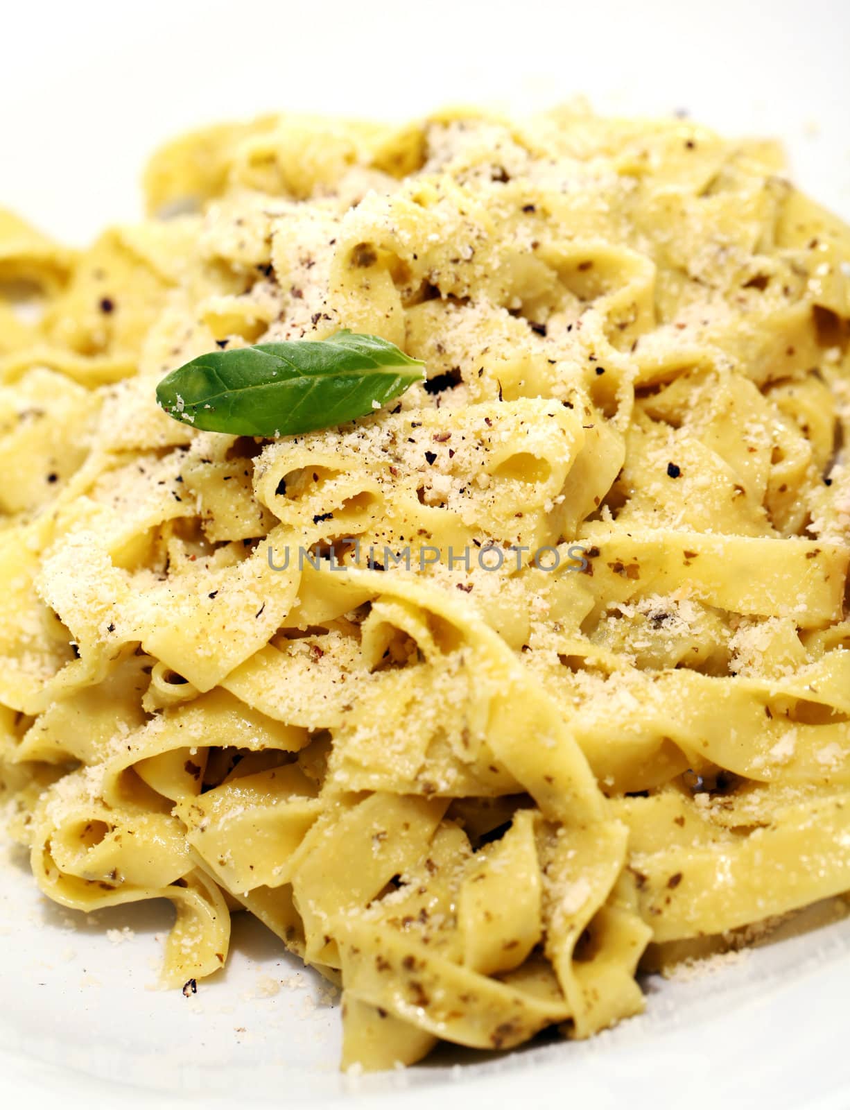 Italian pasta with basil on a plate isolated on white background