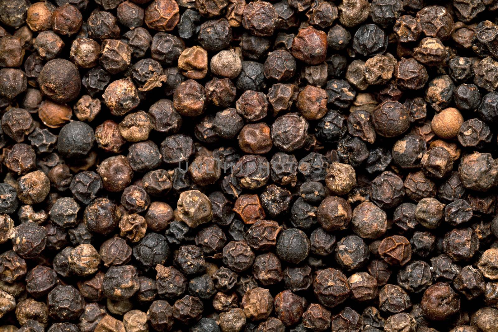Black peppercorn seeds background. Macro shot, top view